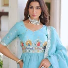 "Close-up portrait of woman wearing peplum blouse in turquoise with embroidered yoke and mirror work detailing, accessorized with statement diamond choker and earrings"