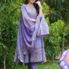 Purple cotton anarkali kurti with floral print dupatta and embroidered neckline, worn with matching printed leggings and white hair accessory