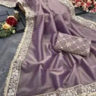 Flat lay photography of premium purple twill tissue saree showing heavy lace border and unstitched mirror work blouse piece.